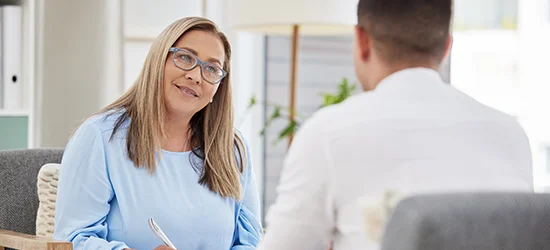 Psychologist sitting with patient in her office and smiling